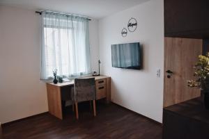 的住宿－Das Joes Frühstückspension，一间房间,配有一张桌子和一台墙上的电视
