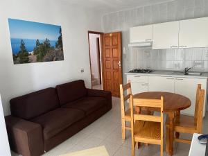 sala de estar con sofá, mesa y cocina en Apartamentos Tanajara, en La Restinga