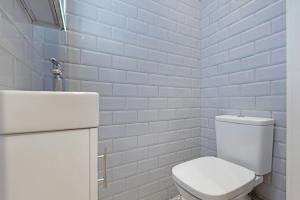 Baño blanco con aseo y lavamanos en Huge 3 bedroom house in London E17 en Londres