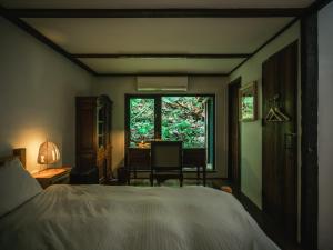 1 dormitorio con cama, escritorio y ventana en Deep Breath B&B en Fengshan