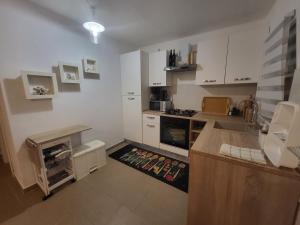 a kitchen with white cabinets and a counter top at Kuća za odmor Zip in Murter