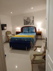 1 dormitorio con 1 cama extragrande y 1 silla en Les Gites Capra - La parisienne en Paray-Vieille-Poste