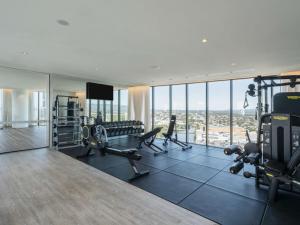 Luxury Casino Apartment in Broadbeach Island في غولد كوست: صالة ألعاب رياضية مع العديد من أجهزةالجري والأجهزة في المبنى