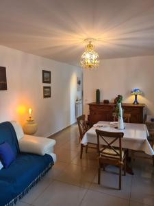 - un salon avec un canapé bleu et une table dans l'établissement Les Gites Capra - La parisienne, à Paray-Vieille-Poste