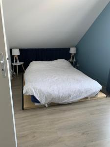 un letto in una camera da letto con due lampade sul pavimento di Chambre cosy à Houilles a Houilles