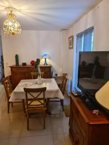 a dining room with a table and a tv at Les Gites Capra - La parisienne in Paray-Vieille-Poste
