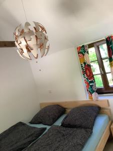 1 dormitorio con cama y lámpara de araña en Pulvermühle - 3 Zimmer Maisonette inkl Bad am Stettbach im NATURA 2000 Gebiet mit 12500 qm Garten, en Seeheim-Jugenheim