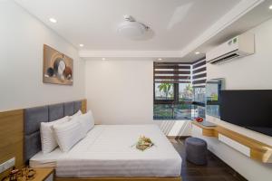 a bedroom with a bed and a flat screen tv at HSuites Riverside Hotel and Apartment in Da Nang