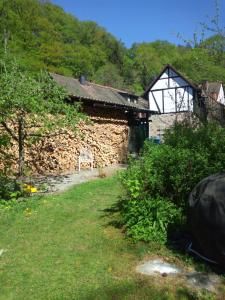 un edificio con una pared de piedra junto a un patio en Pulvermühle - 3 Zimmer Maisonette inkl Bad am Stettbach im NATURA 2000 Gebiet mit 12500 qm Garten, en Seeheim-Jugenheim