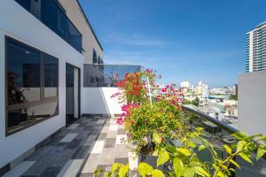a balcony with flowers and plants on a building at HSuites Riverside Hotel and Apartment in Danang