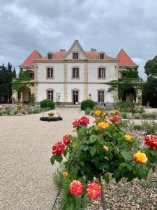 uma casa grande com flores em frente em La Bellonette em Marseillan