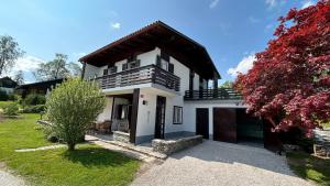 a white house with a balcony and a yard at COSY VINTAGE HOUSE in Bled