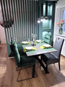 a dining room table with two chairs and a table with plates at Bei den Reymann´s in Nollingen