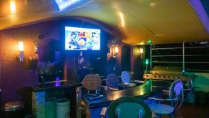 a room with a bar with chairs and a tv at Fields Palace Hotel in Angeles