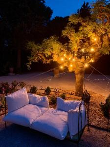 un canapé assis devant un arbre avec des lumières dans l'établissement La Bellonette, à Marseillan