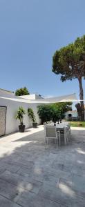 un patio con mesa, sillas y un árbol en Villa yoli 26 chalet con piscina cerca de la playa, en Chiclana de la Frontera