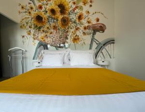 1 dormitorio con 1 cama con manta amarilla y bicicleta en Le 36 Maison d'hôtes Piscine & Spa en La Flotte