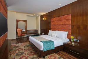 1 dormitorio con 1 cama grande y cabecero de madera en Zone by The Park, Jammu en Jammu