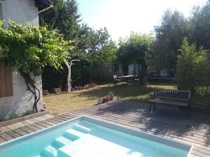 a swimming pool in a yard with a bench at La Maison du Béchon in Blanquefort