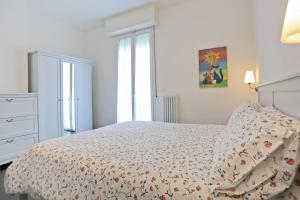 een witte slaapkamer met een bed en een raam bij Casa Vacanze Aurora Centro in Rimini