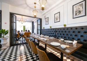 a dining room with a long table and chairs at Le Thatluang D'oR Boutique Hotel in Vientiane