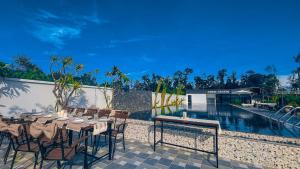 a patio with a table and chairs next to a pool at Dreamers Farm in Vinh Thanh