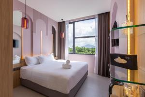 une chambre d'hôtel avec un lit et une fenêtre dans l'établissement Wellesley Hotel, à Simpang Ampat