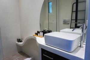uma casa de banho com um lavatório branco e um espelho. em Sani Pine em Sani Beach