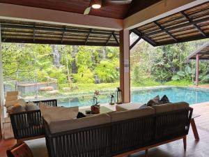 a living room with a couch and a swimming pool at Rarin Villas in Chiang Mai