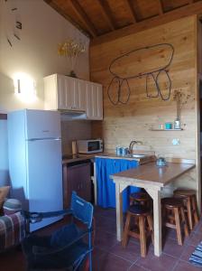 a kitchen with a table and a refrigerator at Habitación Da Moura in Maus de Salas