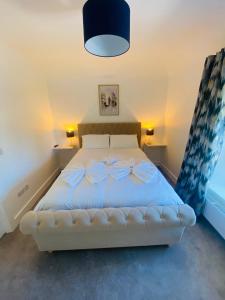 a bedroom with a white bed with bows on it at Farmhouse in Virginia County Cavan in Cavan