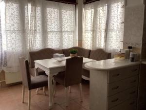a white table and chairs in a kitchen with curtains at Cozy and Spacious Villa in Golbası