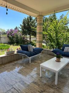 un patio con 2 sofás azules y una mesa en Cozy and Spacious Villa, en Golbası