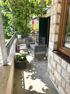 a patio with benches and a table and a window at Apartman Anja in Budva