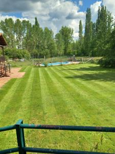 un gran campo de césped con parque infantil en Apartamento piscina jardin Lara, en San Martín de Valdetuéjar