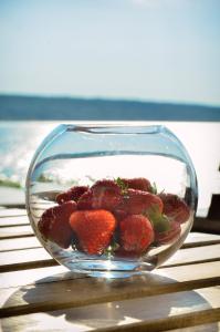 a glass bowl filled with strawberries on top of a table at Apartmani Perić 1 Meka Draga in Obrovac