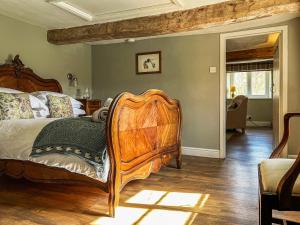 a bedroom with a wooden bed in a room at Chipley Escapes - Otters Holt in Milverton