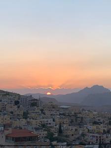 a view of a city at sunset at Rafiki Hostel in Wadi Musa