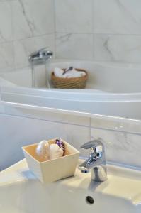 a bathroom sink with a box of donuts on it at Apartmani Perić 1 Meka Draga in Obrovac +49 photos