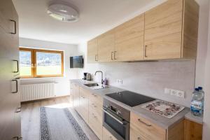 a kitchen with wooden cabinets and a sink at Haus Zak in Scharnitz