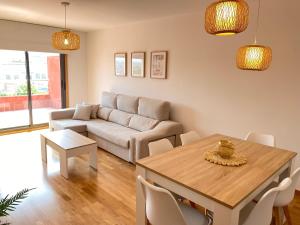 a living room with a table and a couch at PreaMar apartamento acogedor con terraza in Laxe