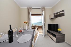 a dining room with a table with a bottle of wine at Apartmani Perić 1 Meka Draga in Obrovac