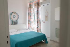 a bedroom with a bed with a blue blanket and a window at Dimora Di Meglio a un passo dal mare in Ischia