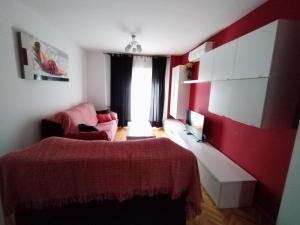 1 dormitorio con cama y pared roja en Apartamento El Alfar, en Talavera de la Reina