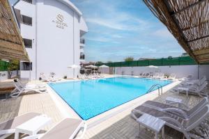 a swimming pool with white lounge chairs and a hotel at A Hotel Side in Side