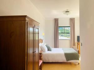 Vinhais Hotel في فينهيس: غرفة نوم بسرير ونافذة