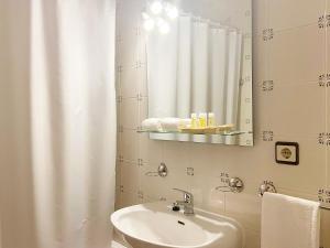 een badkamer met een wastafel en een spiegel bij Vinhais Hotel in Vinhais