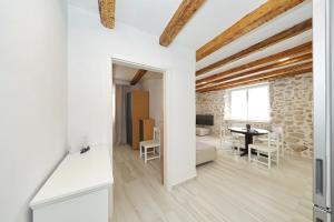 ムルテルにあるStone House apartments in the center of Murter townの白い壁と木製の天井のオープンリビングルーム