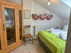 a bedroom with a bed and a chair and a mirror at Gasthaus 3-Länderblick Mönichkirchen in Mönichkirchen