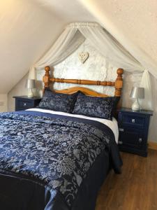 1 dormitorio con 1 cama grande y 2 mesitas de noche en Mc Courts Cottage, en Hilltown